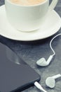 Mobile phone with connected headphones and coffee with milk. Relaxation time with music Royalty Free Stock Photo