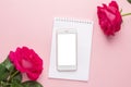 Mobile phone and dark pink rose on a pink background Royalty Free Stock Photo