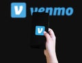 Mobile phone displaying Venmo app logo with hand holding device illustrative Royalty Free Stock Photo