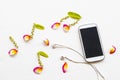 Mobile phone ,earphone with petal coloful flowrers frangipani arrangement music score flat lay style