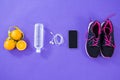 Mobile phone with earphones, shoes, water bottle, lemon and measuring tape