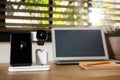 Mobile phone, earphones and smartwatch charging with wireless pad on wooden desk, space for text. Modern device Royalty Free Stock Photo