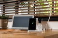 Mobile phone, earphones and smartwatch charging with wireless pad on wooden desk, space for text. Modern workplace device Royalty Free Stock Photo