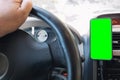Mobile phone with green background inside the car placed on the dashboard