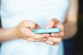 Mobile phone in the hands of a woman. Communication by phone. The girl types a text message on her mobile phone and enjoys a good