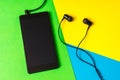 Mobile phone with headphones on colorful background Royalty Free Stock Photo