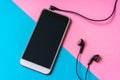 Mobile phone with headphones isolated on colorful background Royalty Free Stock Photo