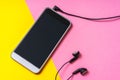 Mobile phone with headphones isolated on colorful background Royalty Free Stock Photo