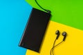 Mobile phone with headphones isolated on colorful background Royalty Free Stock Photo