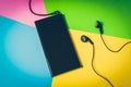 Mobile phone with headphones isolated on colorful background Royalty Free Stock Photo