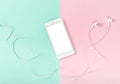 Mobile phone headphones pink blue flat lay background