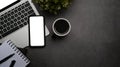 Mobile phone, laptop computer and coffee cup on dark stone background. Flat lay. Royalty Free Stock Photo