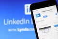 Mobile phone with LinkedIn Learning icon on screen close up with LinkedIn website on laptop. Blurred background. Royalty Free Stock Photo