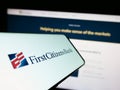 Mobile phone with logo of American financial company First Citizens Bank on screen in front of website.