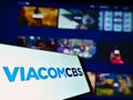 Mobile phone with logo of American mass media company ViacomCBS Inc. on screen in front of business webpage.