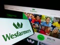 Mobile phone with logo of Australian conglomerate Wesfarmers Limited on screen in front of website.