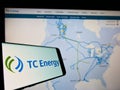 Mobile phone with logo of Canadian company TC Energy Corporation on screen in front of business website.