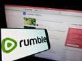 Mobile phone with logo of Canadian video platform company Rumble Inc. on screen in front of website. Royalty Free Stock Photo