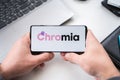 Mobile phone with logo of Chromia CHR blockchain Ethereum platform using in game My Neighbor Alice.Crypto coin,tokens mining