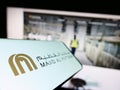 Mobile phone with logo of Emirati company Majid Al Futtaim Group on screen in front of business website.