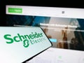 Mobile phone with logo of French company Schneider Electric SE on screen in front of business website. Royalty Free Stock Photo