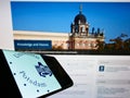 Mobile phone with logo of German university UniversitÃÂ¤t Potsdam on screen in front of website.