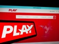 Mobile phone with logo of Icelandic low-cost airline company Fly Play hf. on screen in front of website.