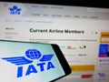 Mobile phone with logo of International Air Transport Association (IATA) on screen in front of website. Royalty Free Stock Photo