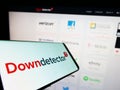Mobile phone with logo of online platform Downdetector (Ookla LLC) on screen in front of website. Royalty Free Stock Photo