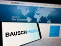 Mobile phone with logo of pharmaceutical company Bausch Health Companies Inc. on screen in front of website. Royalty Free Stock Photo