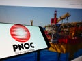 Mobile phone with logo of Philippine National Oil Company (PNOC) on screen in front of business website.