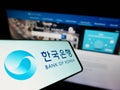 Mobile phone with logo of South Korean central bank Bank of Korea (BOK) on screen in front of business website.