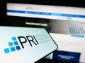 Mobile phone with logo of UN Principles for Responsible Investment (PRI) on screen in front of website.