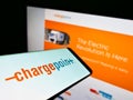 Mobile phone with logo of US company ChargePoint Holdings Inc. (EV charging) on screen in front of business website.