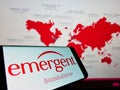 Mobile phone with logo of US company Emergent BioSolutions Inc. on screen in front of business website.