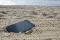 Mobile phone lying on the beach in the sand. weatherproof phones, lost phone concept, data loss a