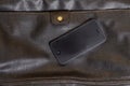 Mobile phone lying on a leather bag Royalty Free Stock Photo