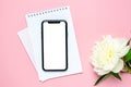 Mobile phone mock up, notebook and peony flower on pink pastel table . Woman working desk.Summer colour Royalty Free Stock Photo