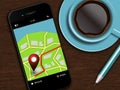 mobile phone with navigation application, coffee and pencil lying on desk