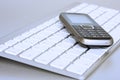 Mobile phone over laptop keyboard Royalty Free Stock Photo