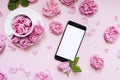 Mobile phone, pink flowers pink background. Place for text. Festive background. Mock up. Postcard template. Congratulation.