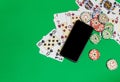 Mobile phone and poker chips with playing cards on a green table.online casino concept. Royalty Free Stock Photo