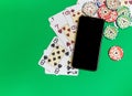 Mobile phone and poker chips with playing cards on a green table.online casino concept Royalty Free Stock Photo