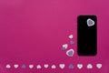 Mobile phone with purple and white felt hearts on a hot pink background - texting, chatting, valentines, love