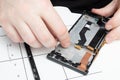 Mobile phone repair. The master removes the loop from the smartphone