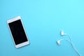 Modern mobile phone earphones blue background copy space.Music is life concept