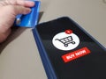 A mobile phone showing Buy Now shopping cart and off focus of a person holding a credit card Royalty Free Stock Photo