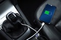 Mobile phone ,smartphone, cellphone is charged ,charge battery with usb charger in the inside of car. modern black car interior Royalty Free Stock Photo