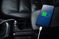 Mobile phone ,smartphone, cellphone is charged ,charge battery with usb charger in the inside of car. modern black car interior Royalty Free Stock Photo