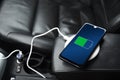 Mobile phone ,smartphone, cellphone is charged ,charge battery with usb charger in the inside of car. modern black car interior Royalty Free Stock Photo